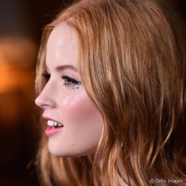 A atriz Ellie Bamber usou uma make com olhos delineados e glitter durante um evento na Califórnia (Foto: Getty Images)
